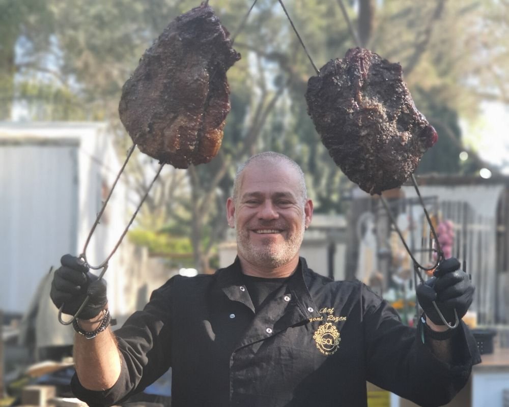 תמונה של יונתן רוזן עם שיפודים גדולים של בשר